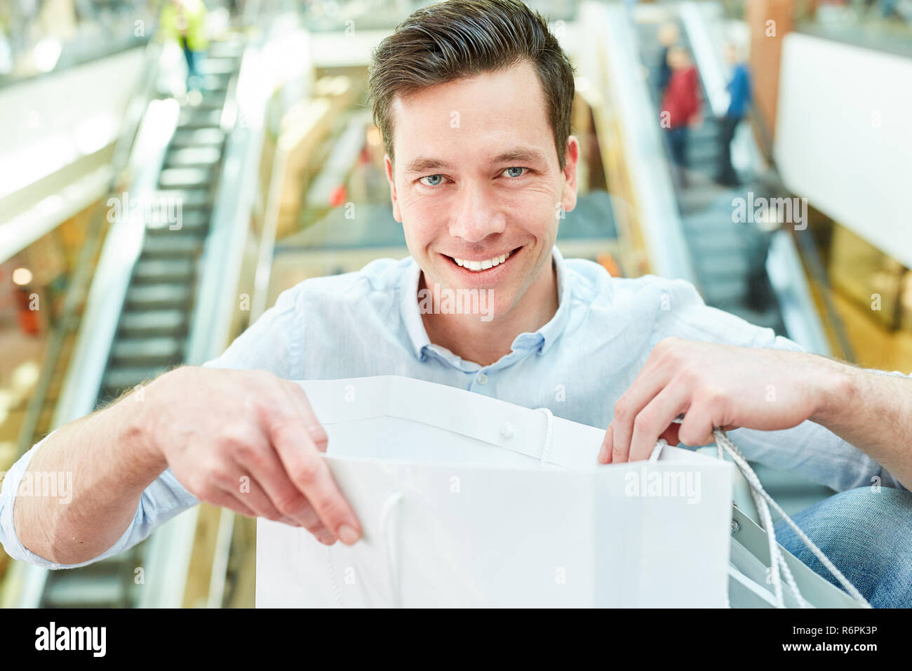 Happy man as a customer and consumer with grocery bag while shopping Stock Photo