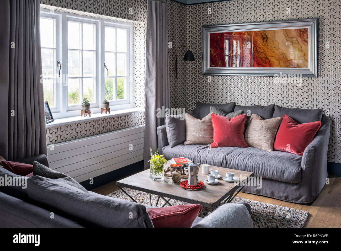 Light grey sofas with large silver framed artwork at window in Hampshire Mill house redesigned by Emma Painter Stock Photo