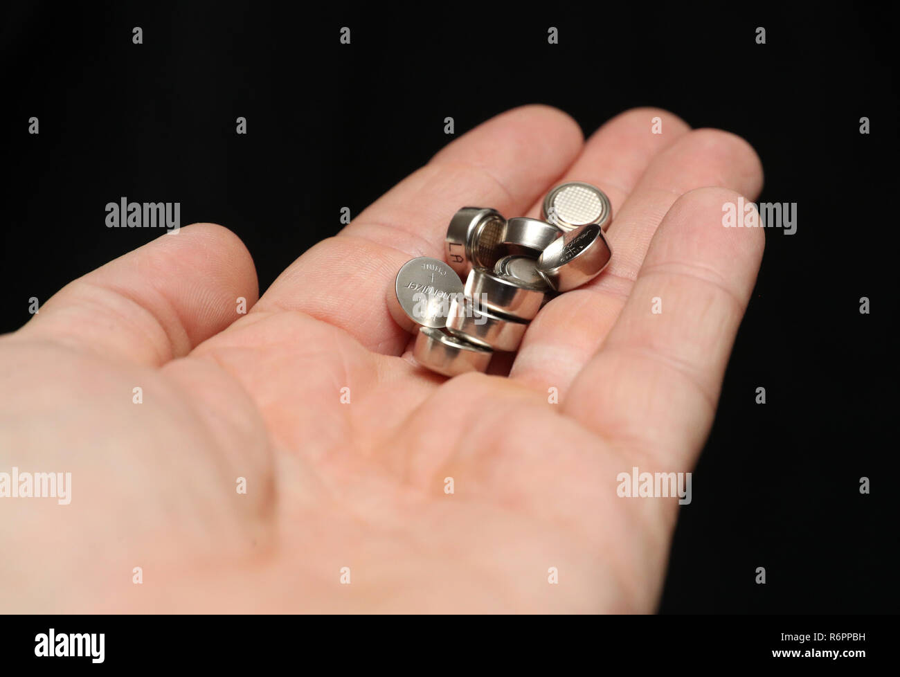 A person holds a pile of Energizer LR44/A76 Alkaline 1.5v batteries in  their hand Stock Photo - Alamy