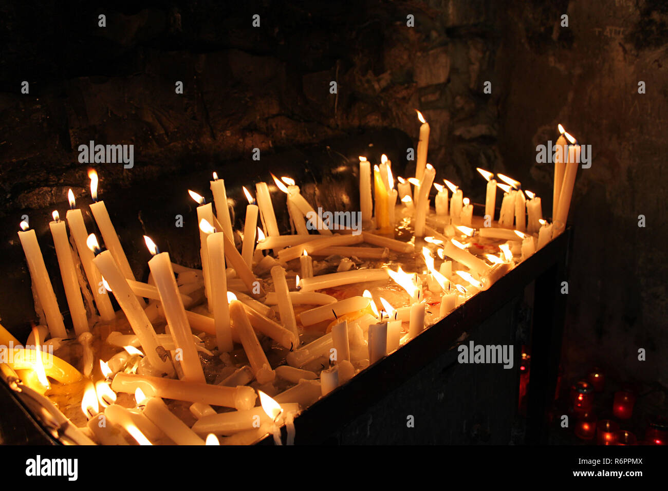 Lighted candles melting in silence in a church of Lebanon Stock Photo