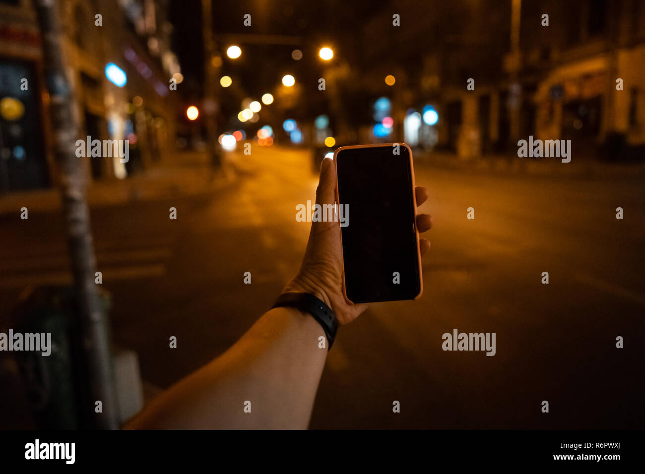 A man's hand holding a smartphone with a black screen Stock Photo - Alamy