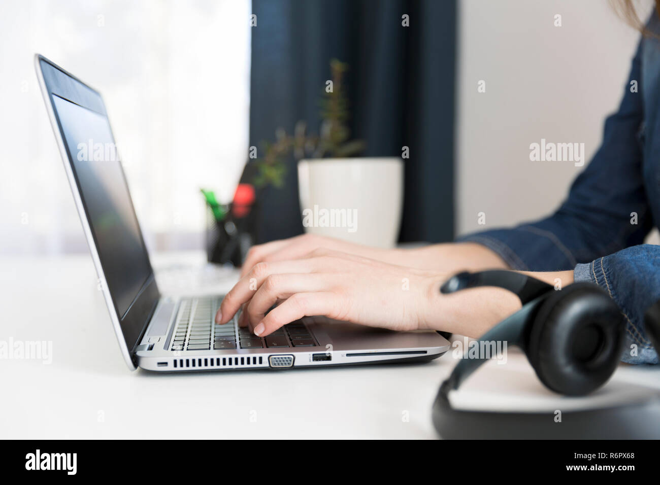 Customer service representative working on laptop at desk in office ...