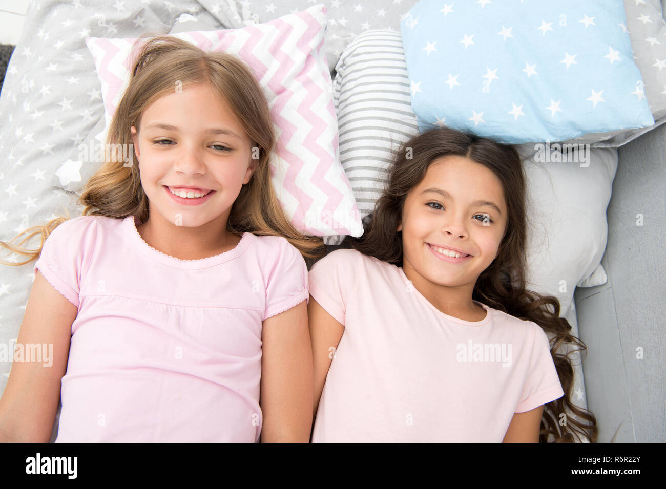 Best friends forever. Girls children lay on bed with cute pillows ...