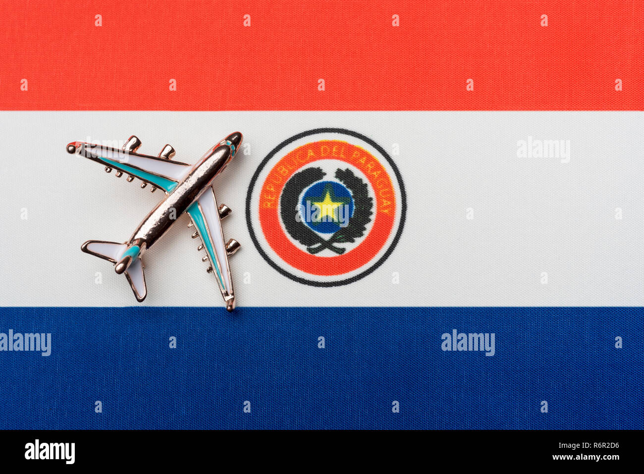 Airplane over the flag of Paraguay travel concept in the country. Toy plane, tourism and travel. Stock Photo