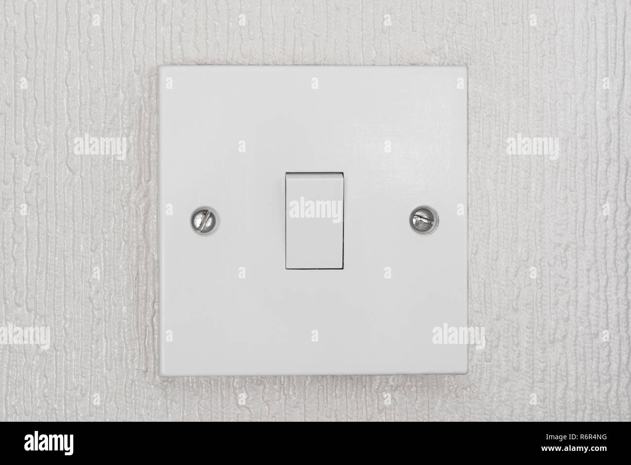 British light switch, in white or ivory colour,  in on position. Stock Photo