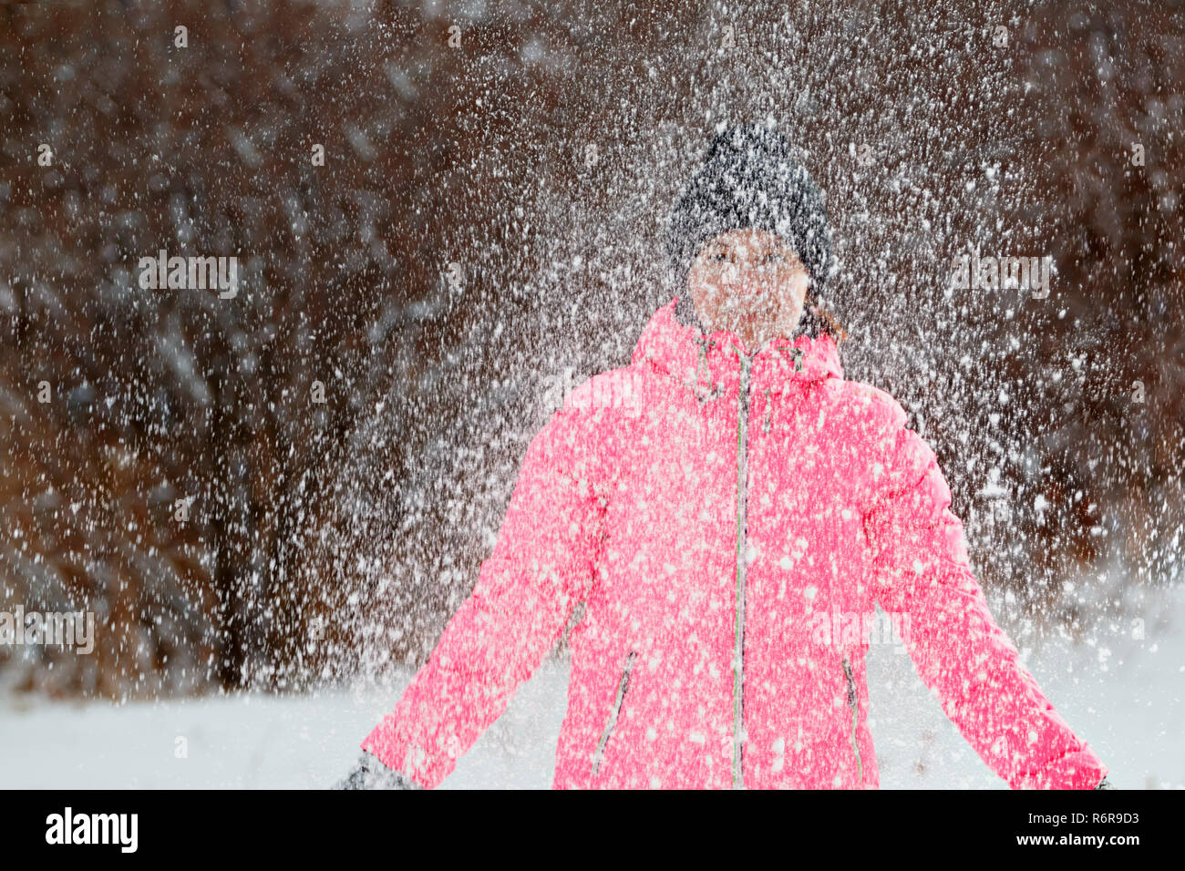 Happy young woman playing with snow in the park. Winter concept. Stock Photo