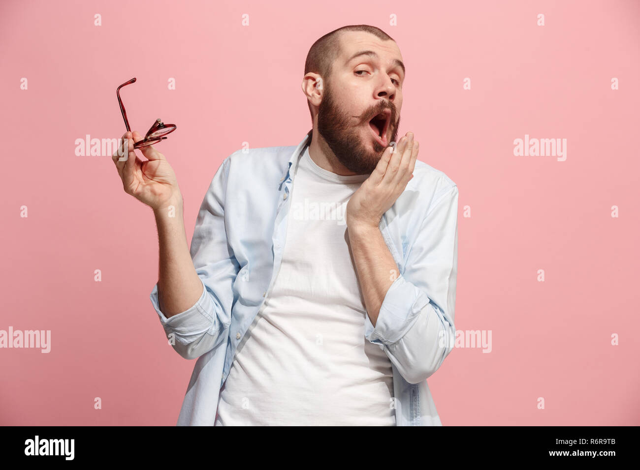 Beautiful bored man bored isolated on pink background Stock Photo