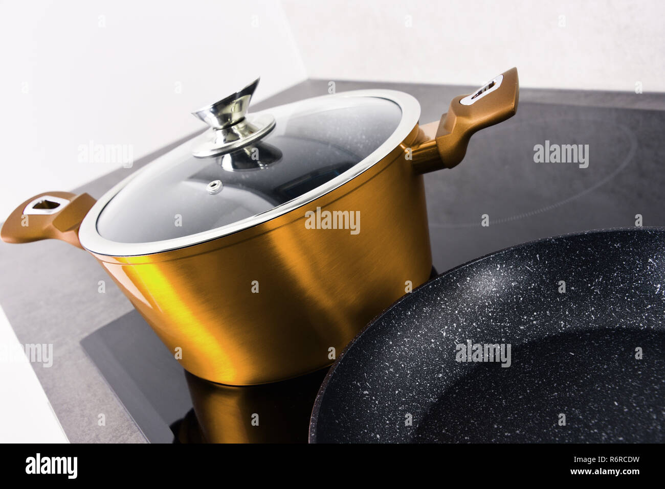Frying pan and steel pot on modern induction cooktop Stock Photo Alamy