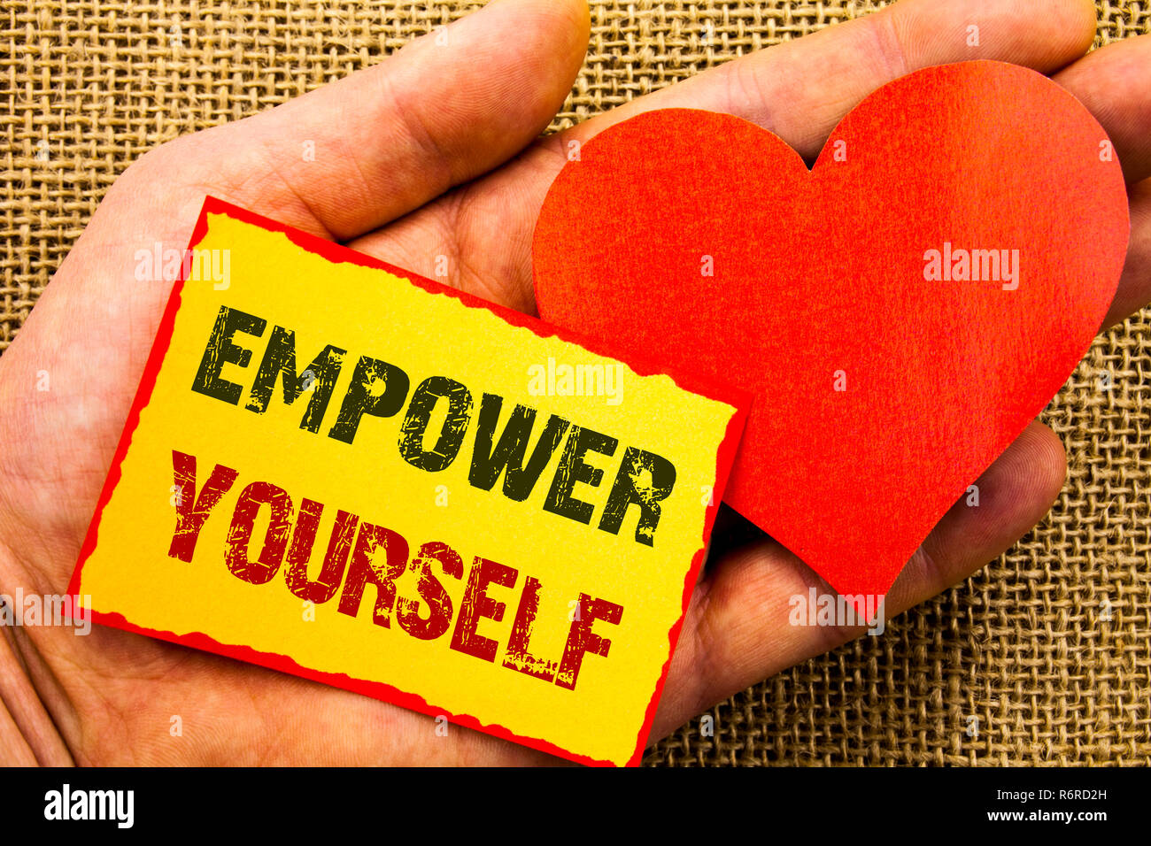 Handwriting text showing Empower Yourself. Business concept for Positive Motivation Advice For Personal Development written on Sticky Note Paper With Heart Holding Hand with Finger. Stock Photo