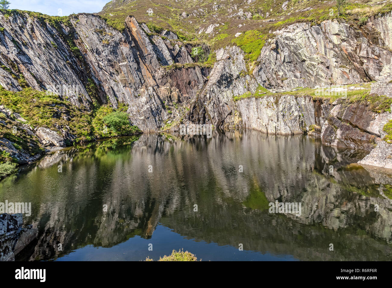A disused and flooded slate quarry on the path towards Moel Siabod, a mountain in the Snowdonia National Park in North Wales. Stock Photo