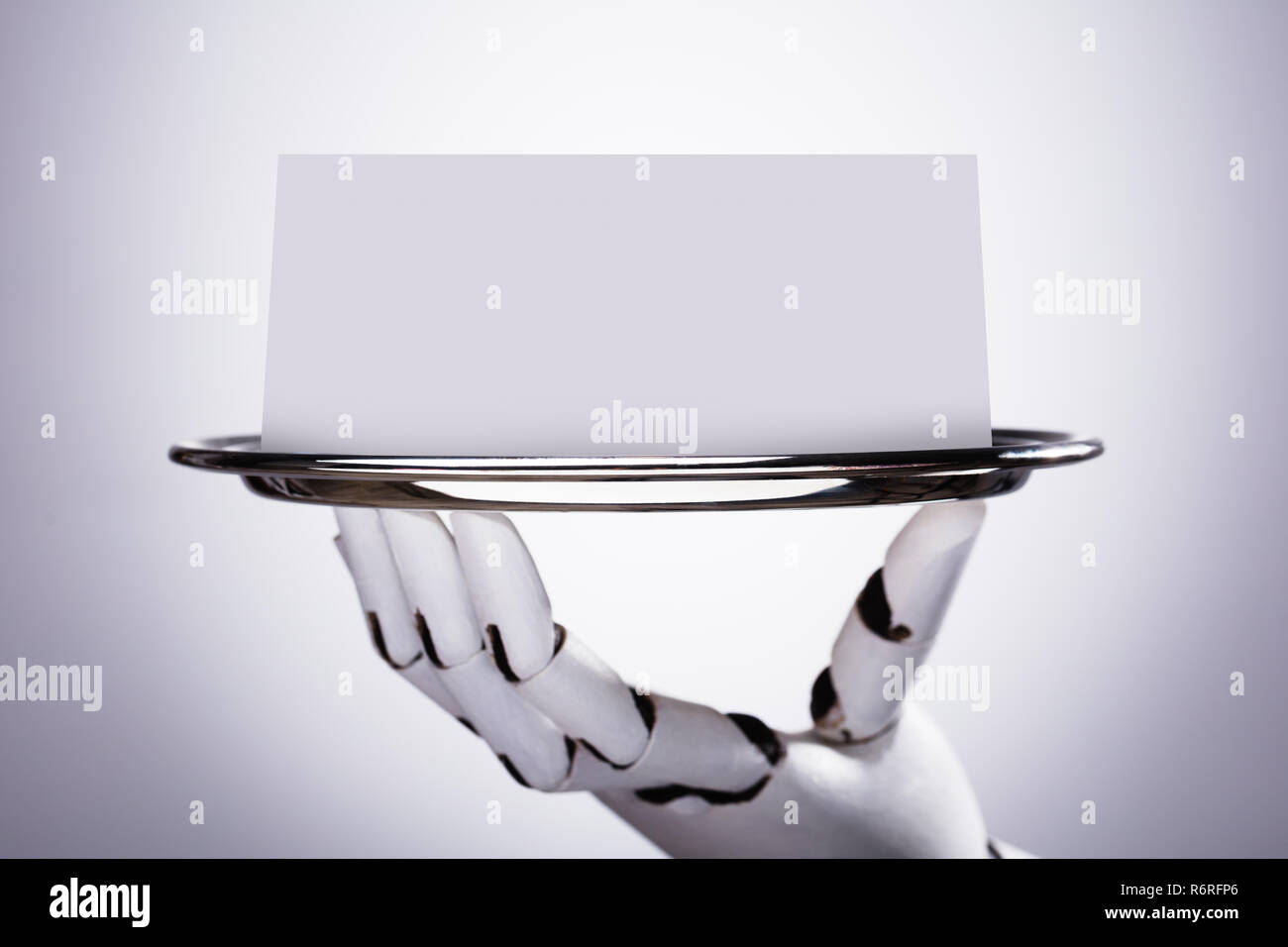 Robot Holding Blank Card In Plate Stock Photo