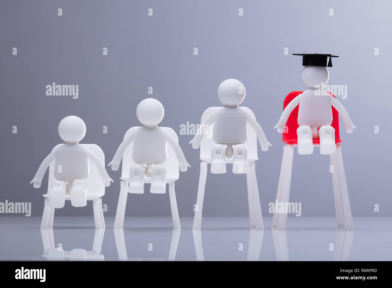 Human Figures Sitting On White And Red Chairs Stock Photo - Alamy