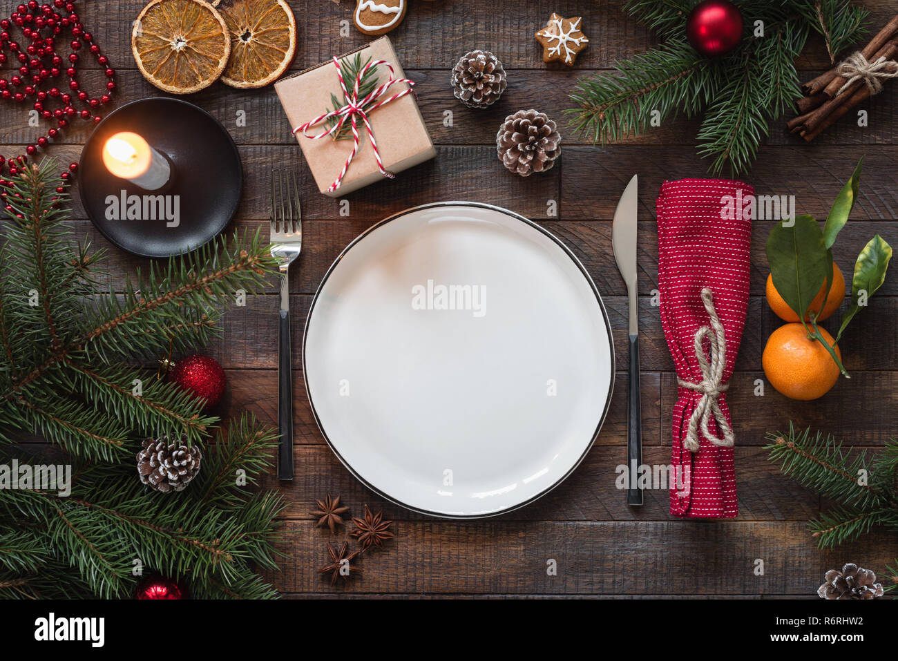 Authentic Christmas Table Setting. Empty Plate, Candles, Silverware, Fir tree, Gift boxes. Top view with copy space for text Stock Photo