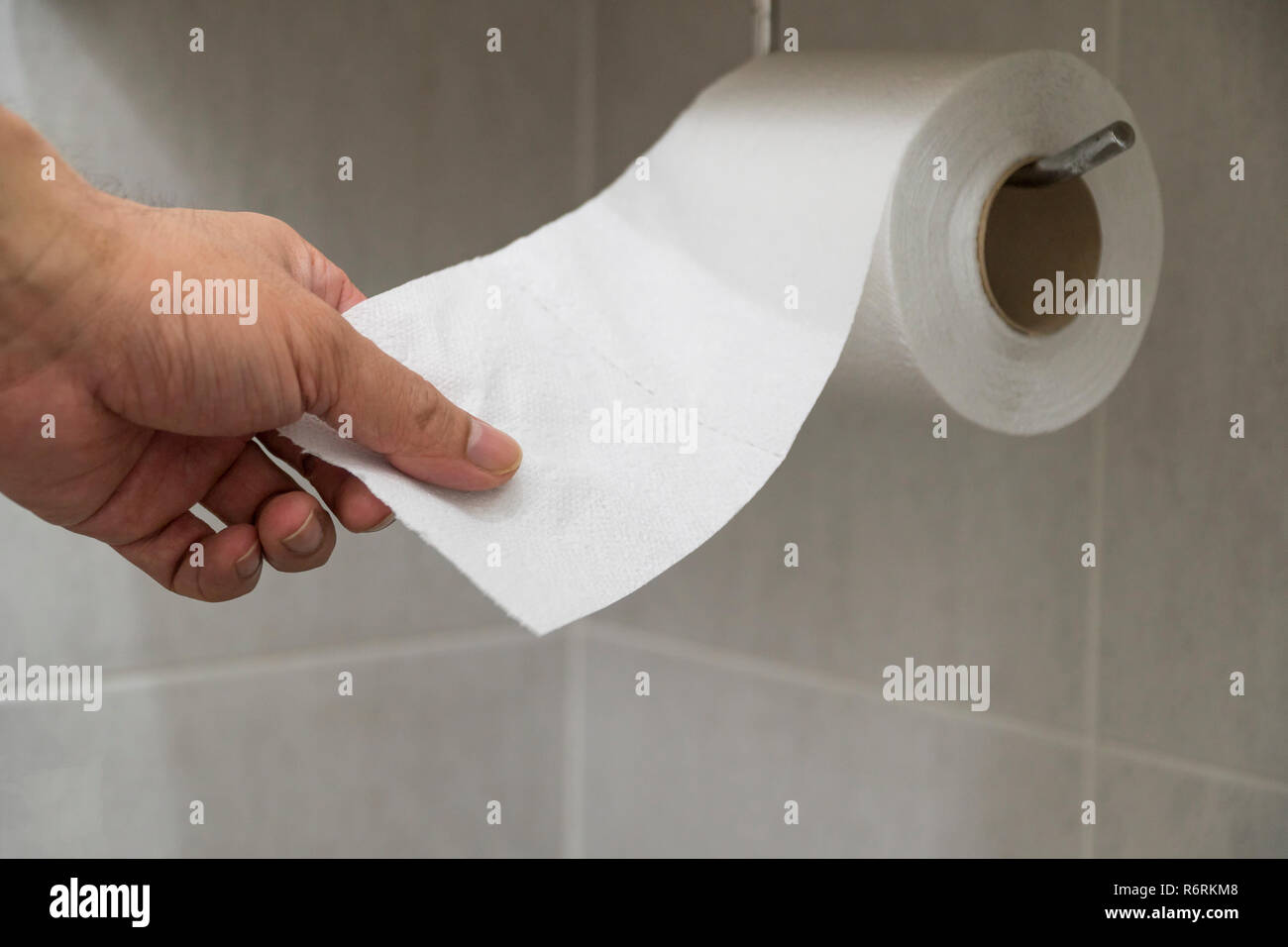 Hand picked toilet paper in the bathroom Stock Photo Alamy