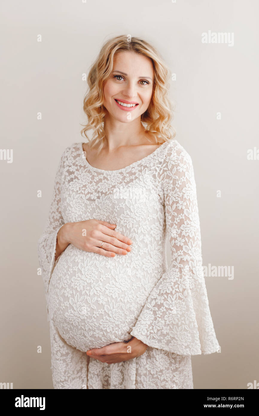 Portrait Of Smiling White Caucasian Blonde Pregnant Woman In White Lacy Portrait Of Smiling White Caucasian Blonde Pregnant Woman In White Lacy