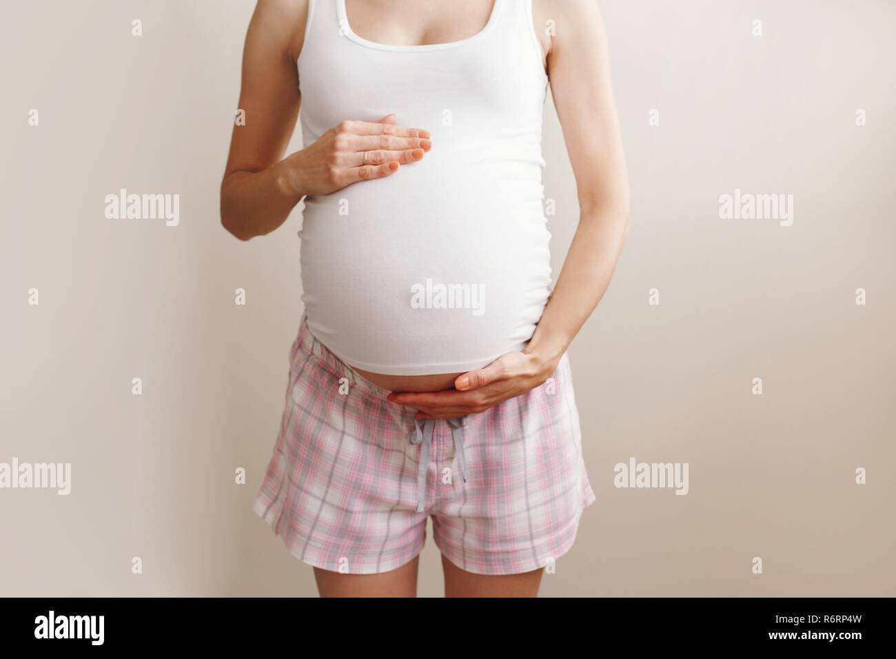 Closeup Body Of White Caucasian Blonde Pregnant Woman In Home Clothes Touching Her Belly 