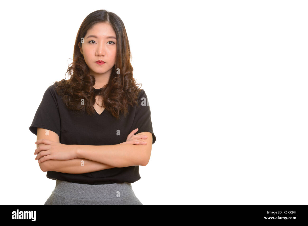 Portrait of young beautiful Asian businesswoman with arms crossed Stock Photo