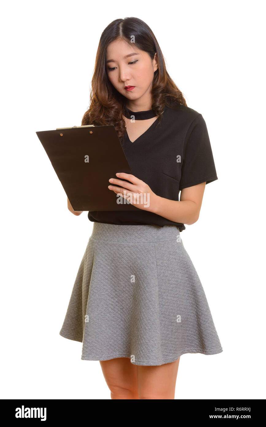 Portrait of young beautiful Asian businesswoman writing report Stock Photo