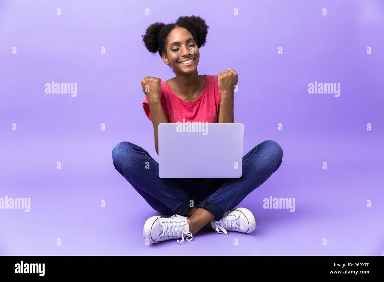 Photo of excited african american woman smiling and using silver laptop ...