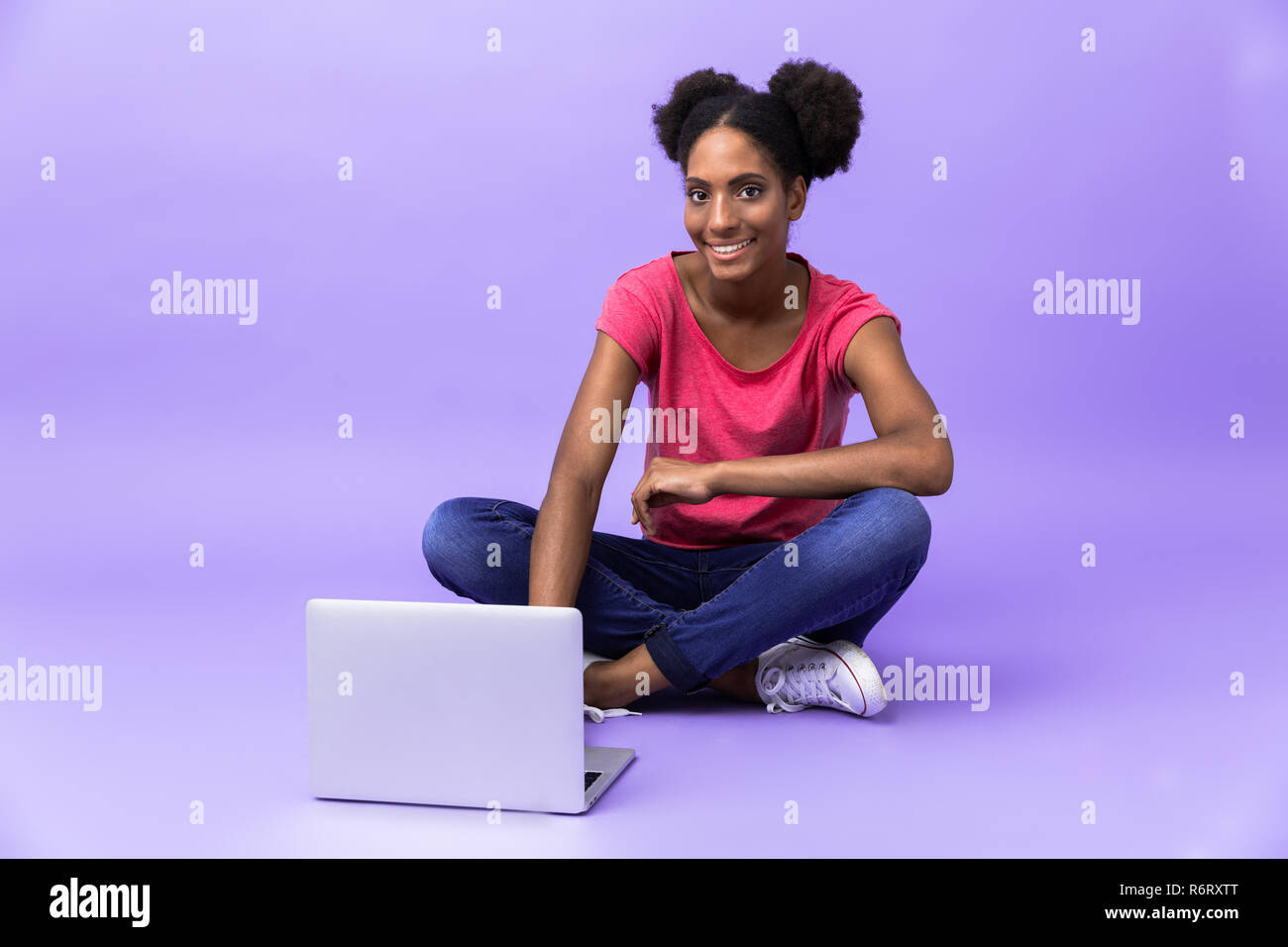 Photo of young african american woman smiling and using silver laptop ...