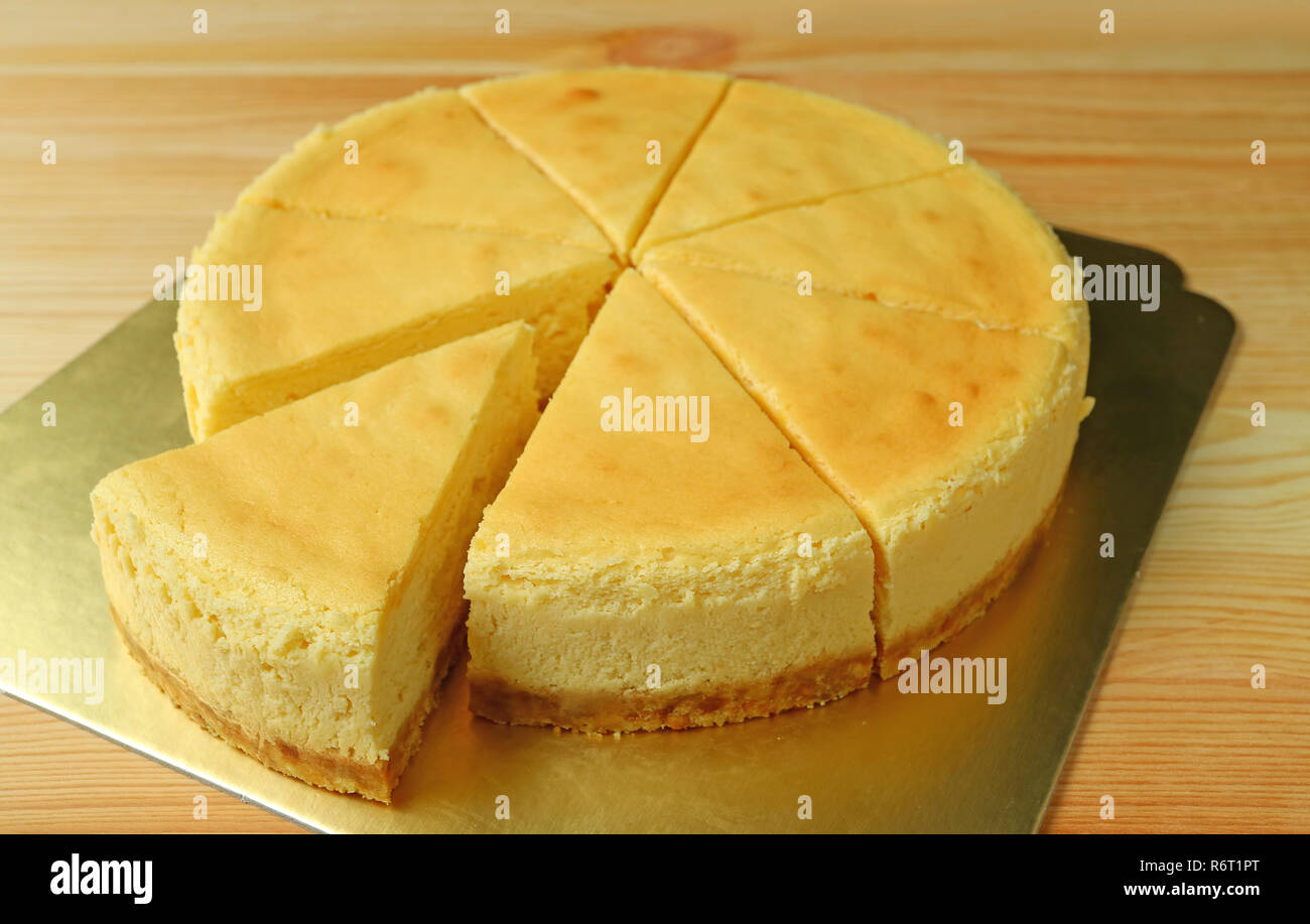 Delicious creamy yellow plain baked cheesecake with one piece cut from