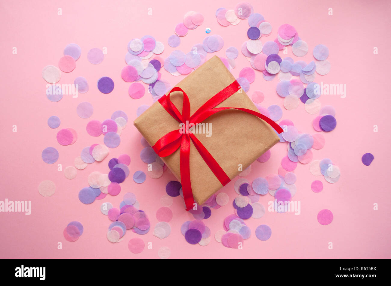 Gift box tied with red ribbon on pastel pink background Stock Photo - Alamy