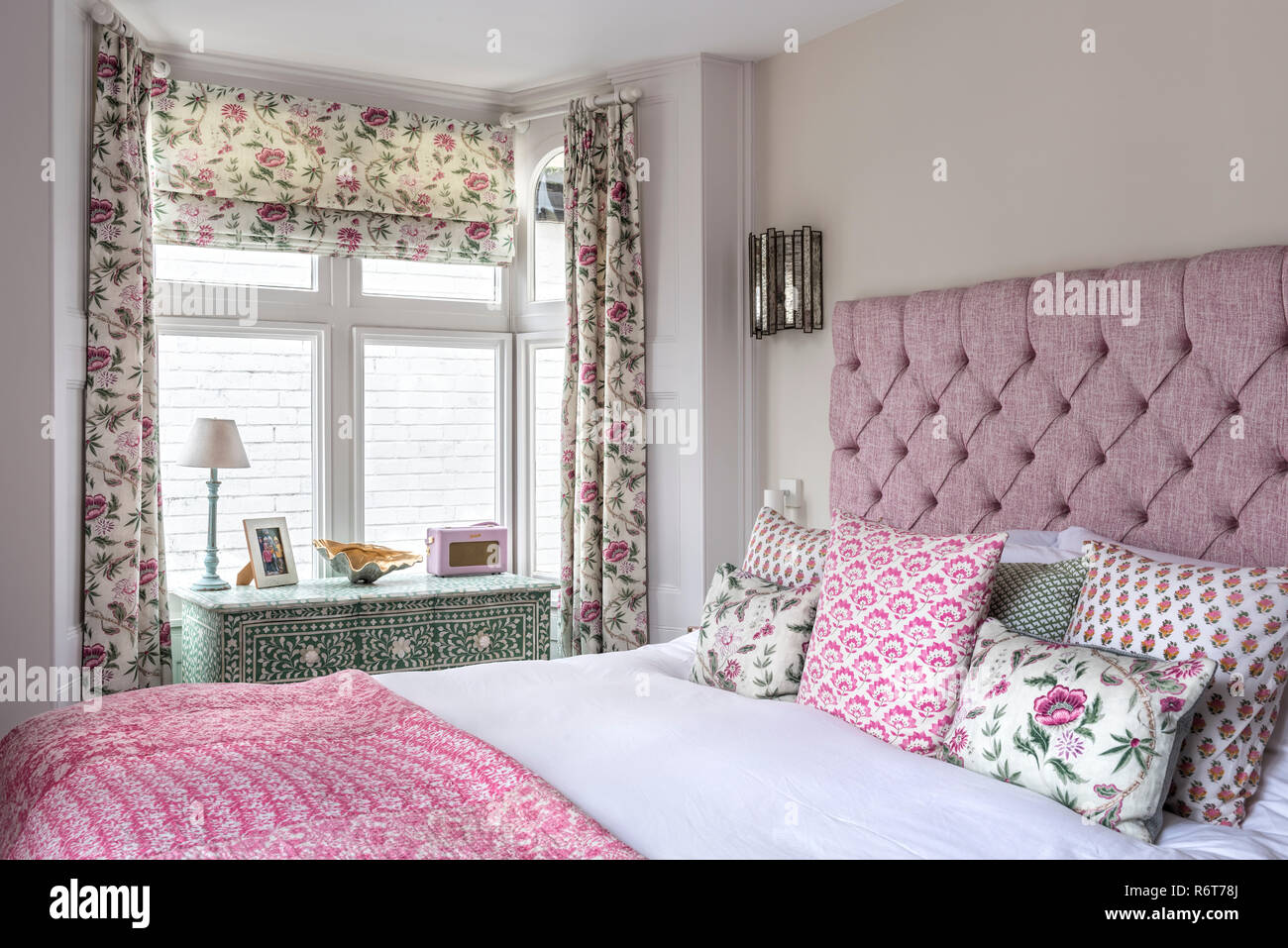 Curtains and Roman blind made up in Helene in fuchsia  from the Fleurons d’Helene collection Stock Photo