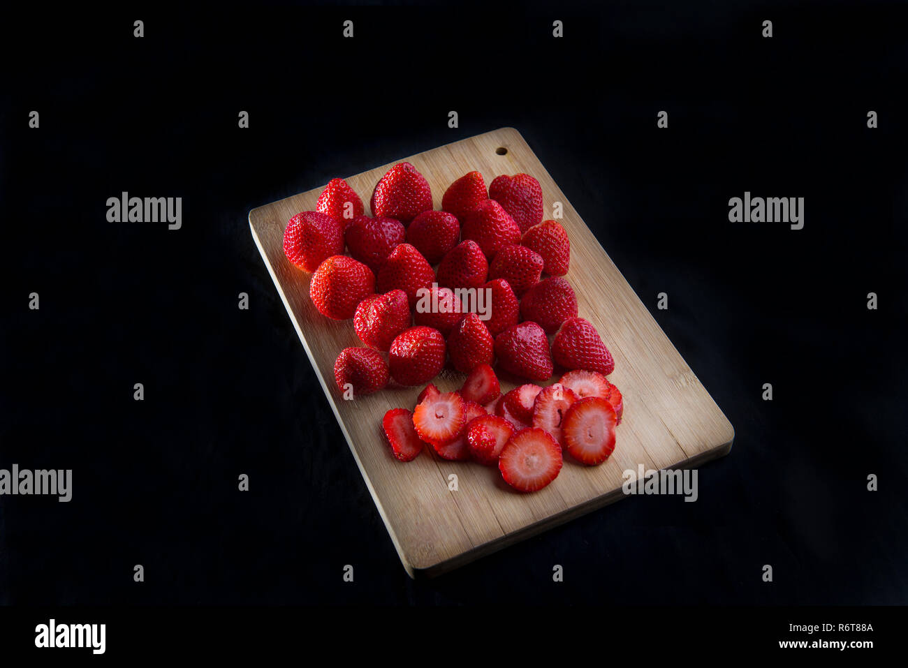 Strawberries on cutting board with black background for marketing purposes Stock Photo