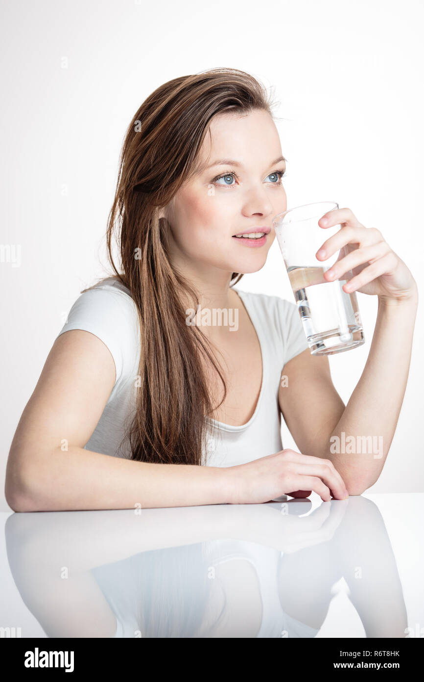 Closeup portrait of a young attractive woman drinking water from glass. Stock Photo