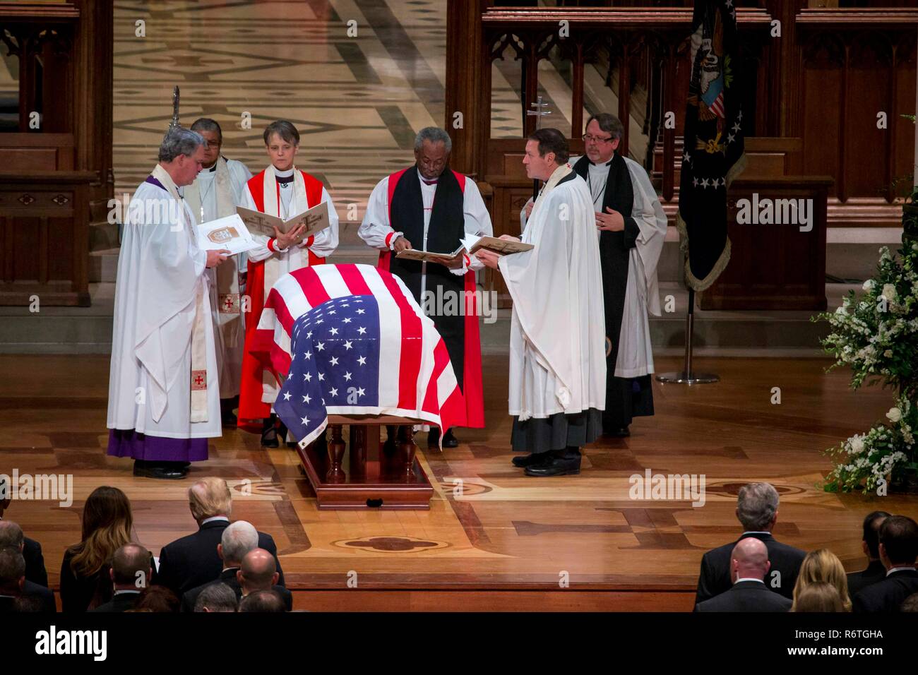 Washington DC, USA. 5th December, 2018. Presiding Bishop Michael Curry, center, and members of the Episcopal clergy perform the funeral rites over the flag draped casket of former U.S President George H.W. Bush during the State Funeral at the National Cathedral December 5, 2018 in Washington, DC. Bush, the 41st President, died in his Houston home at age 94. Credit: Planetpix/Alamy Live News Stock Photo