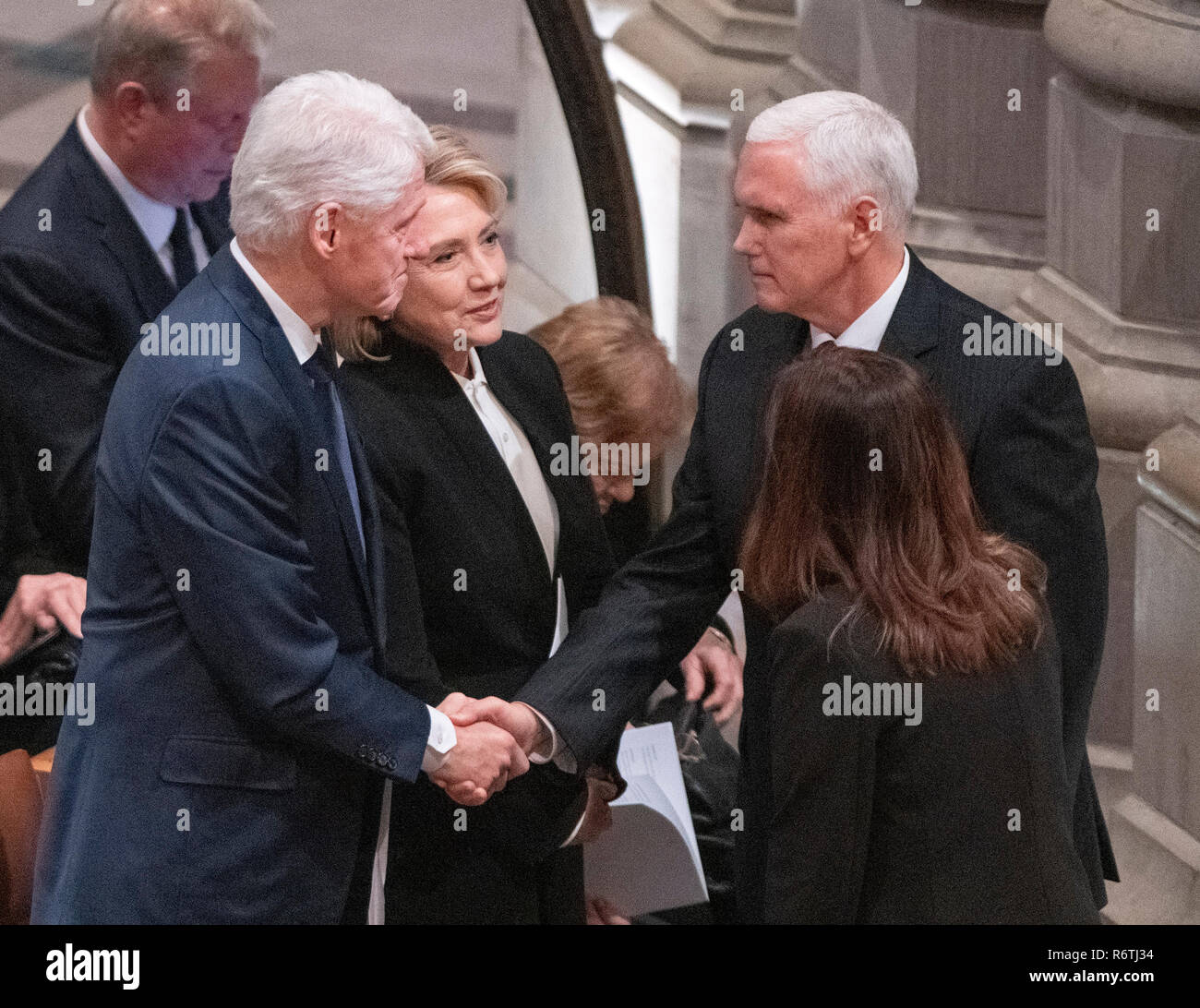 Former United States President Bill Clinton, left, shakes hands with US Vice President Mike Pence, left, as former US Secretary of State Hillary Rodham Clinton, center, looks on prior to the start of the National funeral service in honor of the late former United States President George H.W. Bush at the Washington National Cathedral in Washington, DC on Wednesday, December 5, 2018. Credit: Ron Sachs/CNP (RESTRICTION: NO New York or New Jersey Newspapers or newspapers within a 75 mile radius of New York City) | usage worldwide Stock Photo