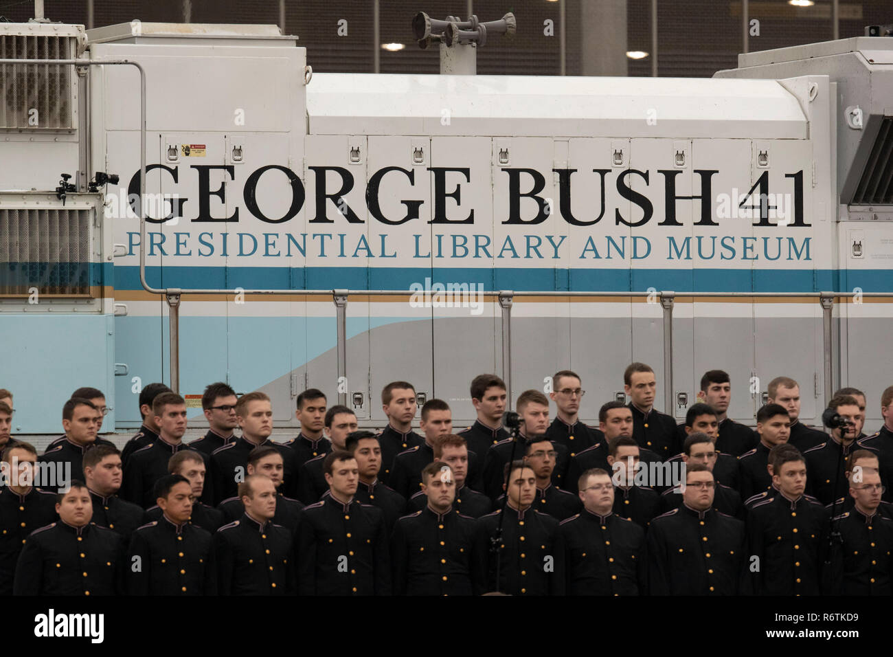 Somber members of Texas A&M University's Singing Cadets stand in front of the train carrying the casket of former President George H.W. Bush upon its arrival from Houston at Texas A&M University for burial at the George Bush Library on campus. Stock Photo