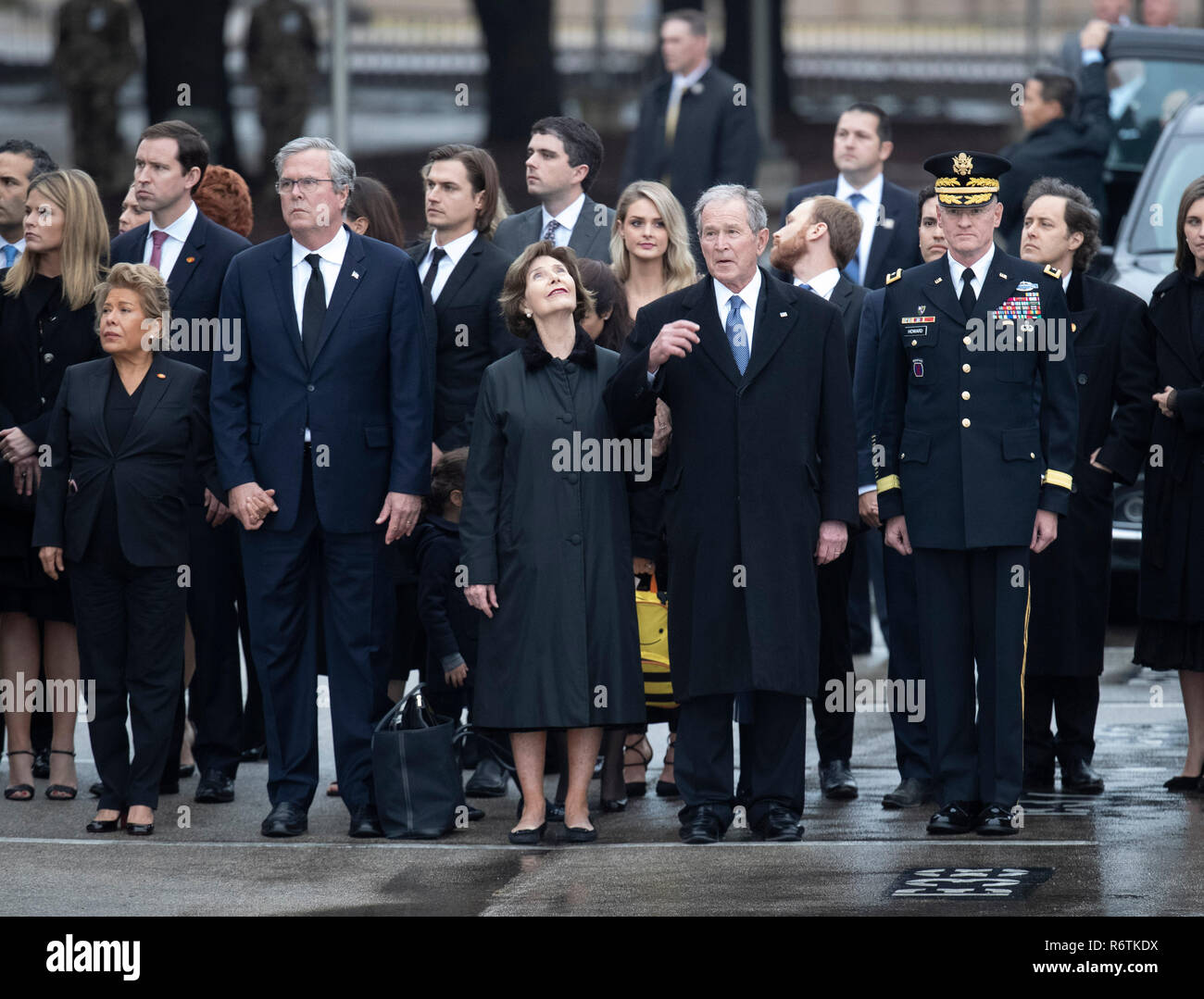 Former Pres. George W. Bush and wife Laur (center), Jeb Bush and wife Paloma (left) and other family members stand at attention as a military honor guard carries the casket of Bush's father, former President George H.W. Bush, to a hearse before burial at the nearby George Bush Library Stock Photo