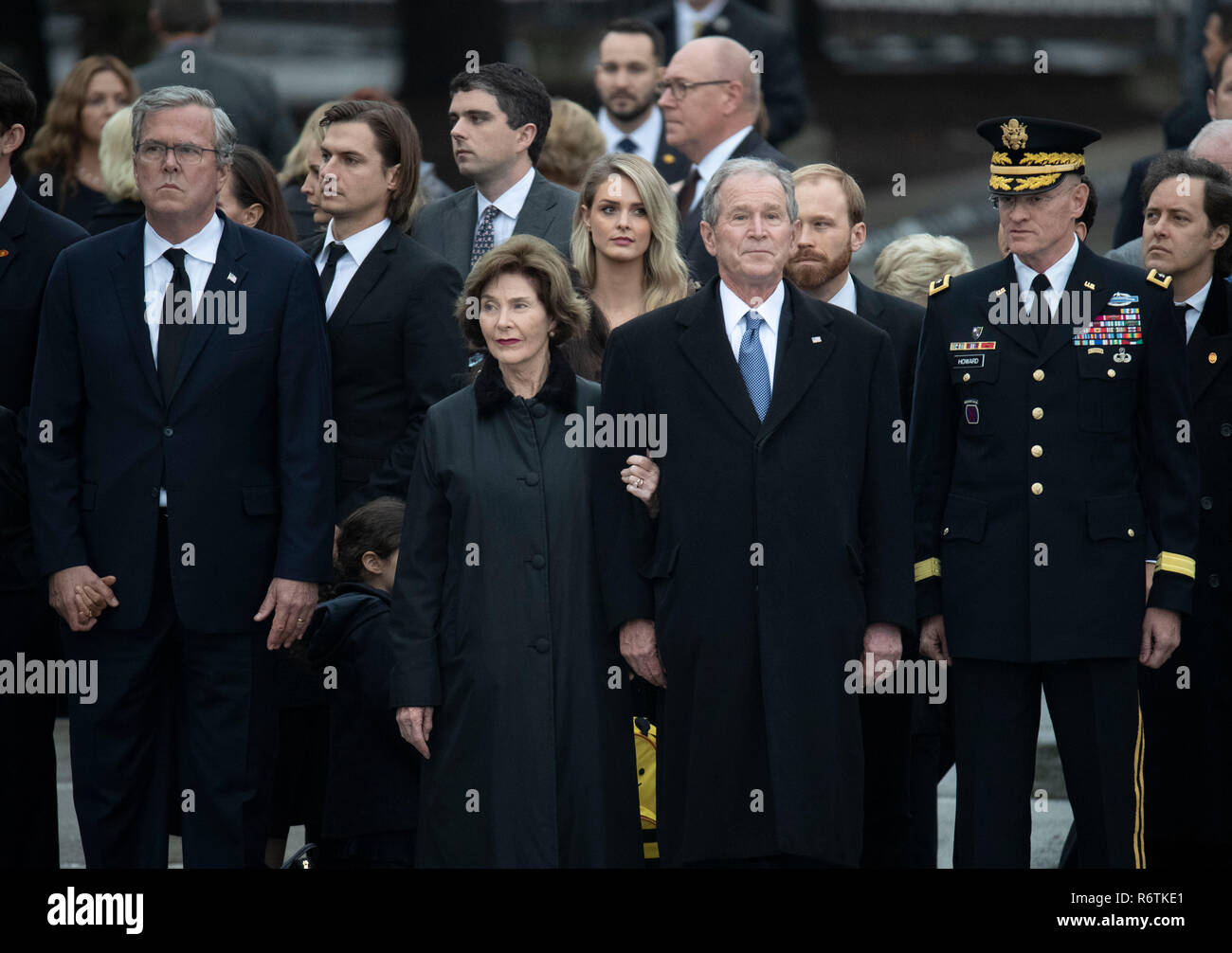 Former Pres. George W. Bush, wife Laura, and other family members stand at attention as a military honor guard carries the casket of Bush's father, former President George H.W. Bush, to a hearse before burial at the nearby George Bush Library Stock Photo