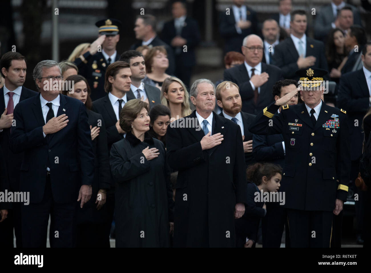 Former Pres. George W. Bush, wife Laura, and other family members stand at attention as a military honor guard carries the casket of Bush's father, former President George H.W. Bush, to a hearse before burial at the nearby George Bush Library Stock Photo