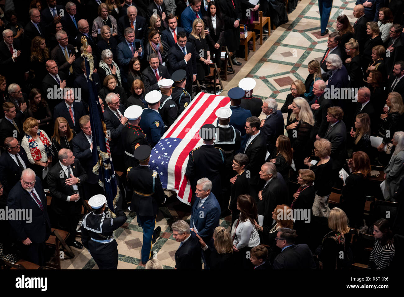 U.S. military honor guard carry the flag draped casket of former president George H.W. Bush down the aisle of the National Cathedral at the conclusion of the State Funeral December 5, 2018 in Washington, DC. Bush, the 41st President, died in his Houston home at age 94 and will be buried at his presidential library at Texas A&M University. Stock Photo