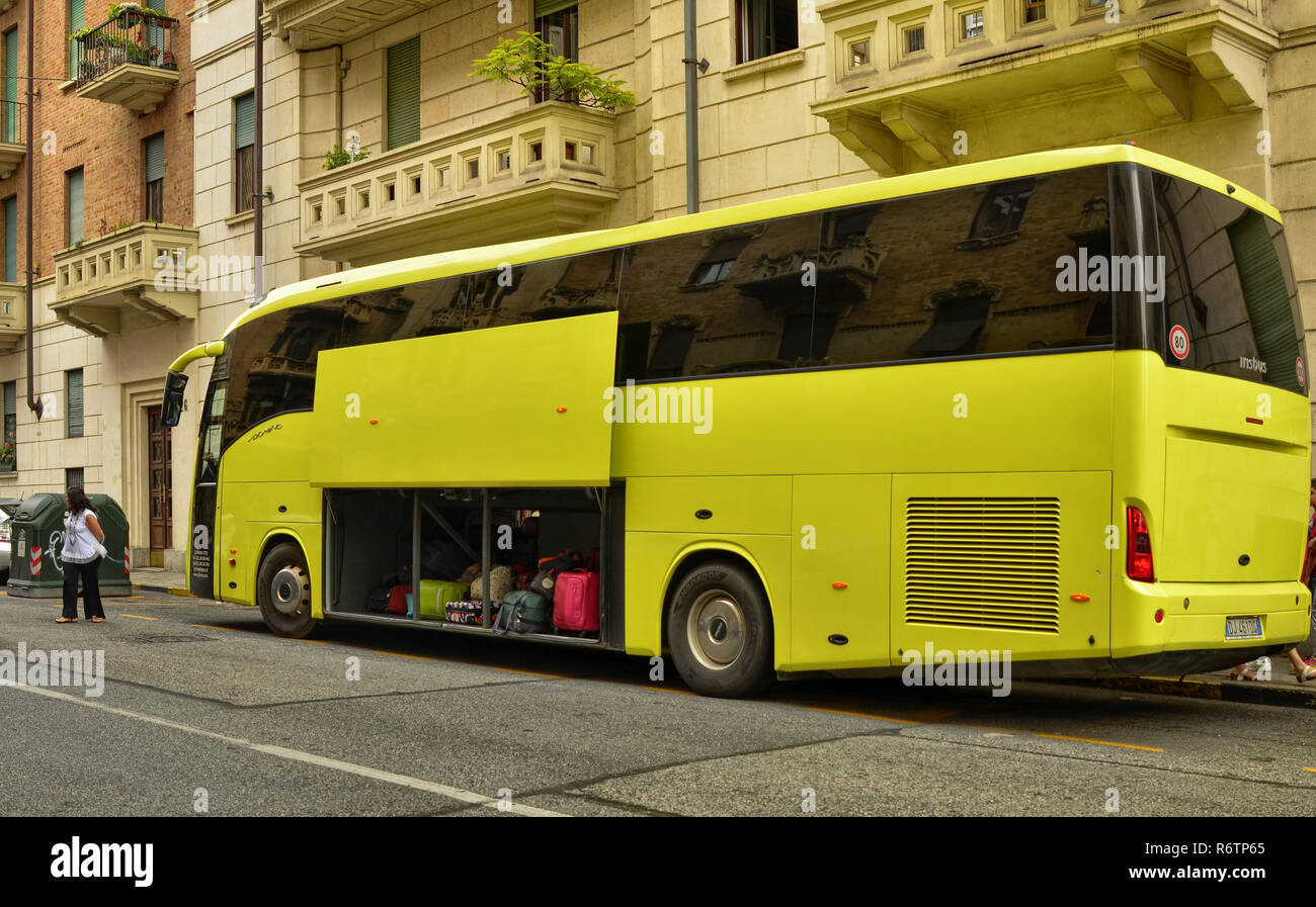 Turin, Piedmont, Italy. July 2018. Departure for the boys' summer camp: the big yellow bus is loaded with the backpacks of the boys. As everything is  Stock Photo