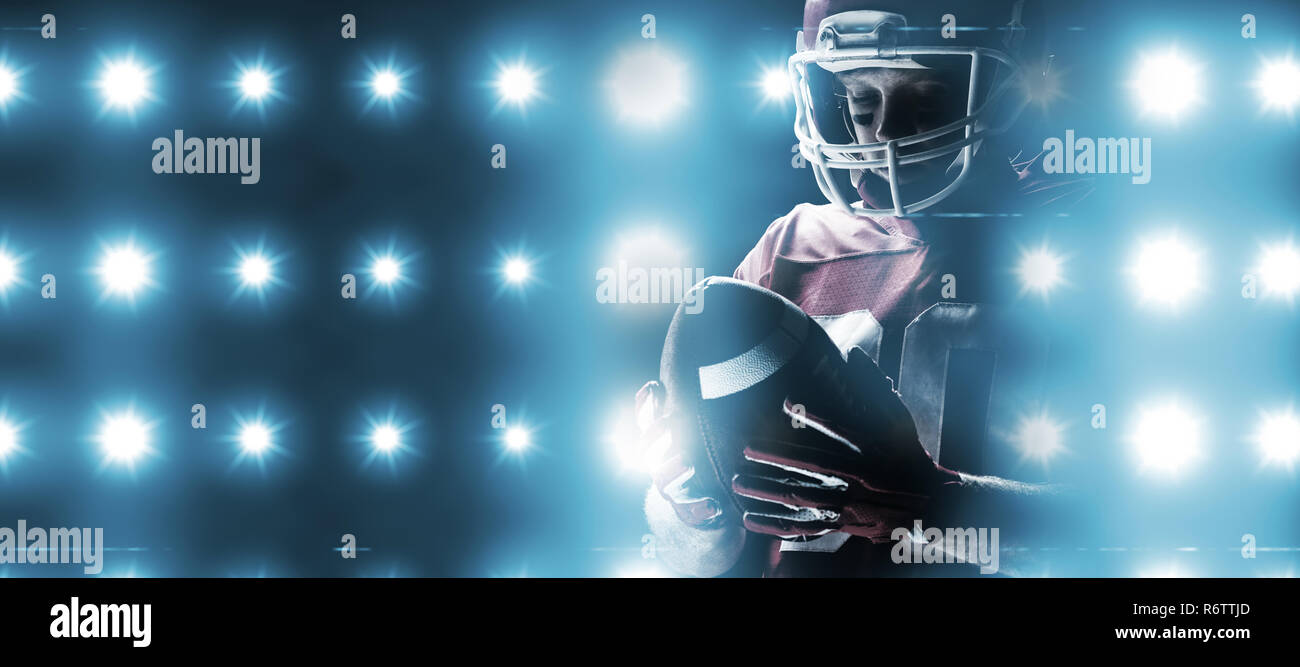 Digitally generated image of blue spotlight  against american football player with helmet looking at rugby ball Stock Photo