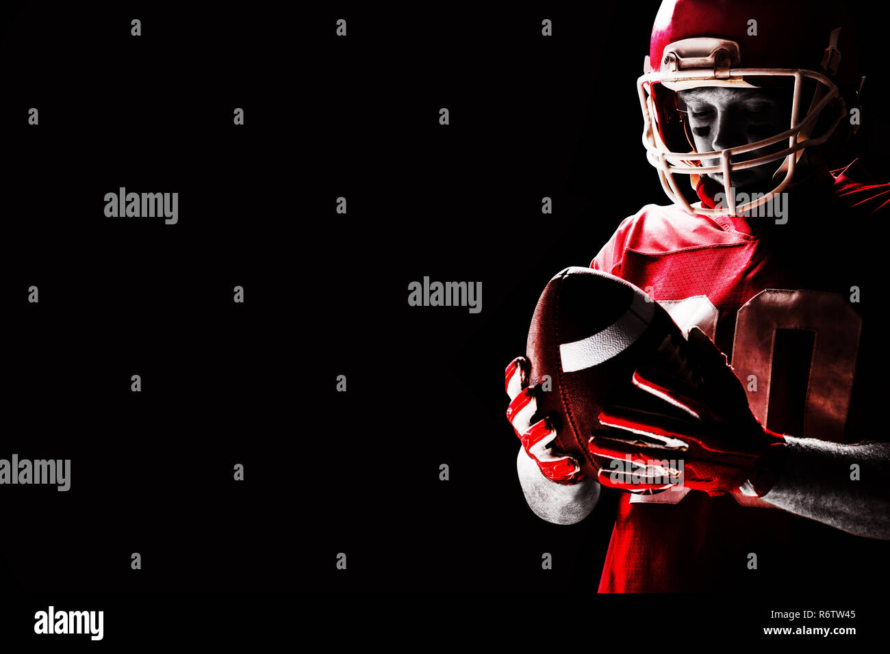 Young American football player standing with rugby helmet and rugby ball Stock Photo