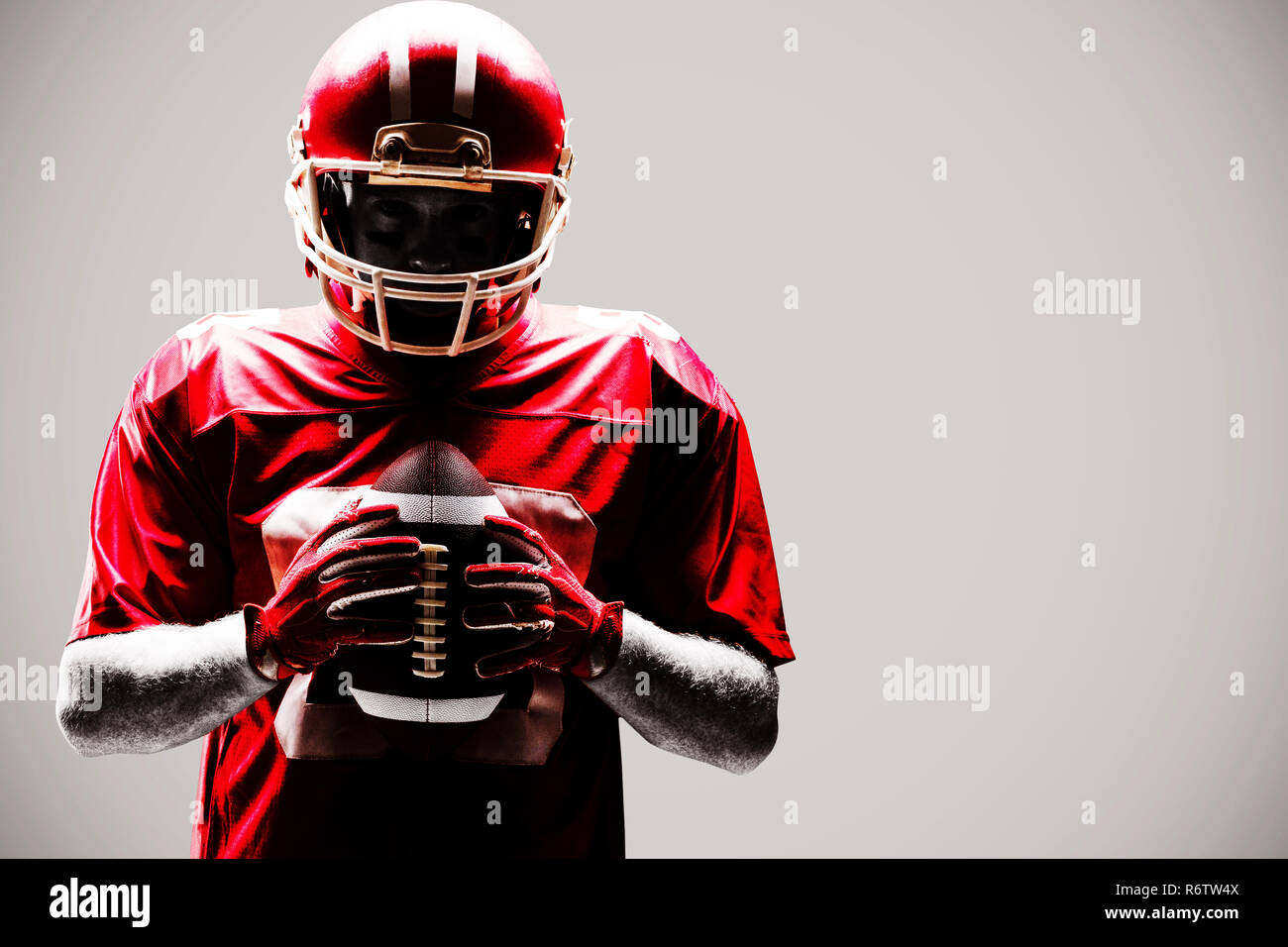 Young  American football player standing with rugby helmet and ball Stock Photo