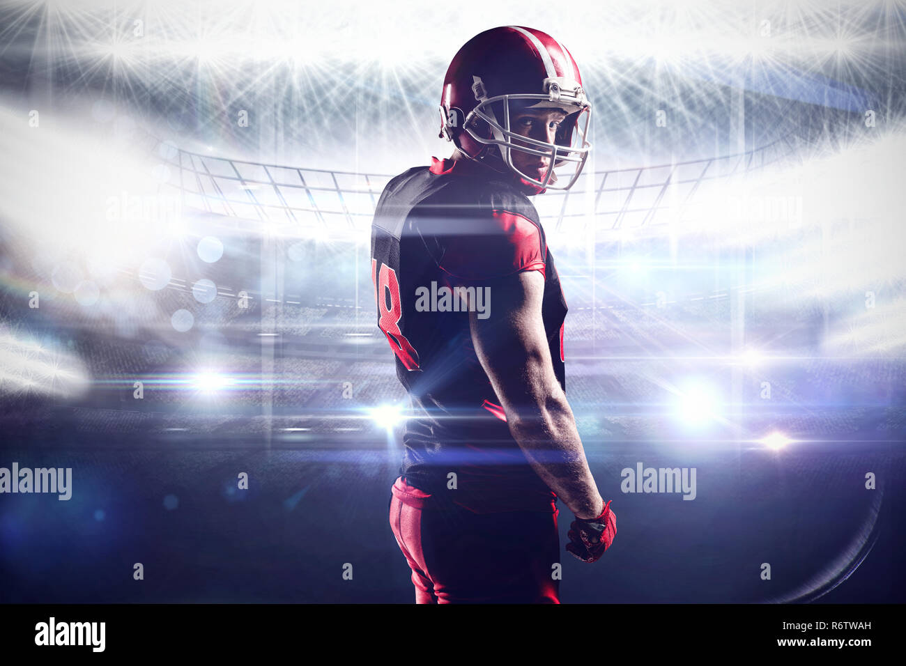 American football player standing in helmet against american football arena Stock Photo