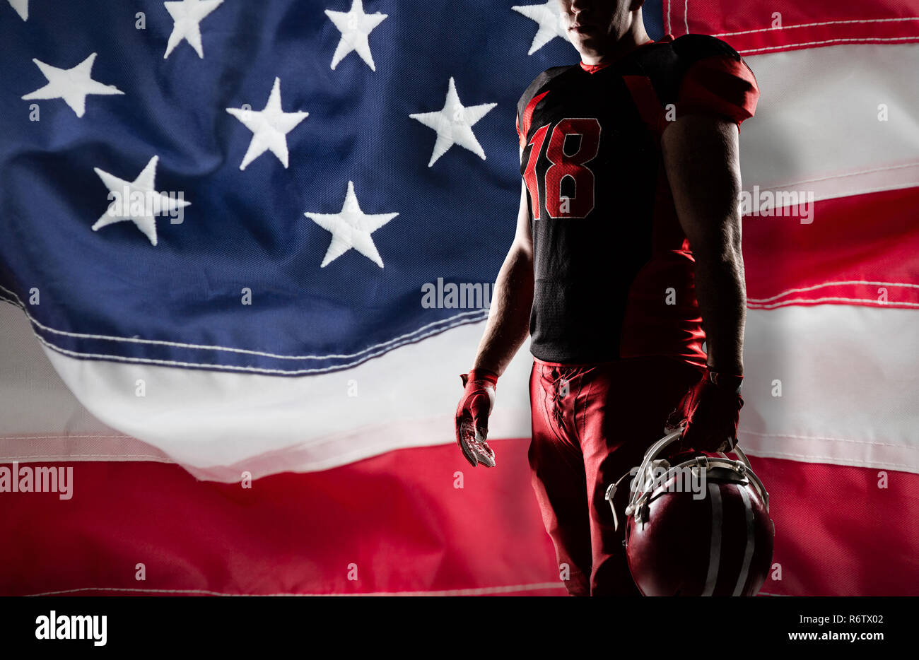 Volleyball player holding rugby helmet against full frame of american flag Stock Photo