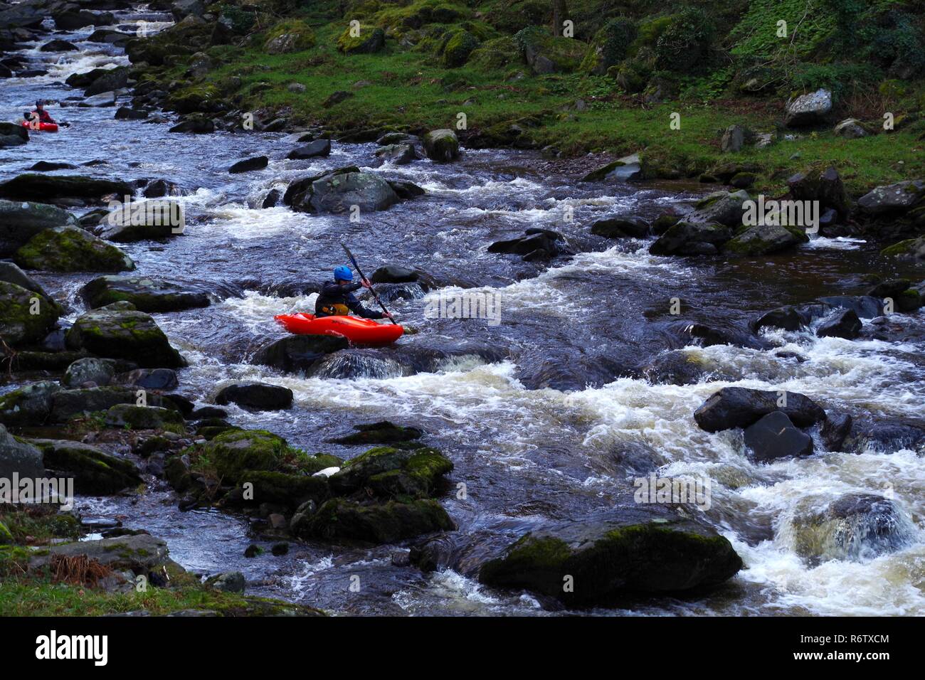 Man in Red Kayak Going Down the East Lyn River. Exmoor National Park, North Devon, UK Stock
