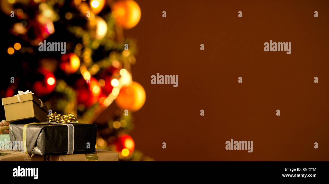 Christmas decorations hanging on wall against copy space with a christmas tree Stock Photo