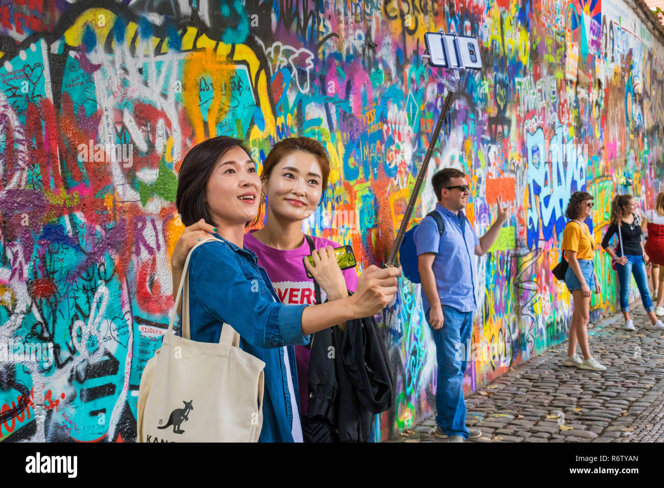 Chinese tourists Prague Lennon Wall Lennonova zeď  chinese women taking a selfie Prague Velkopřevorské náměstí, Malá Strana Prague Czech Republic Europe Stock Photo