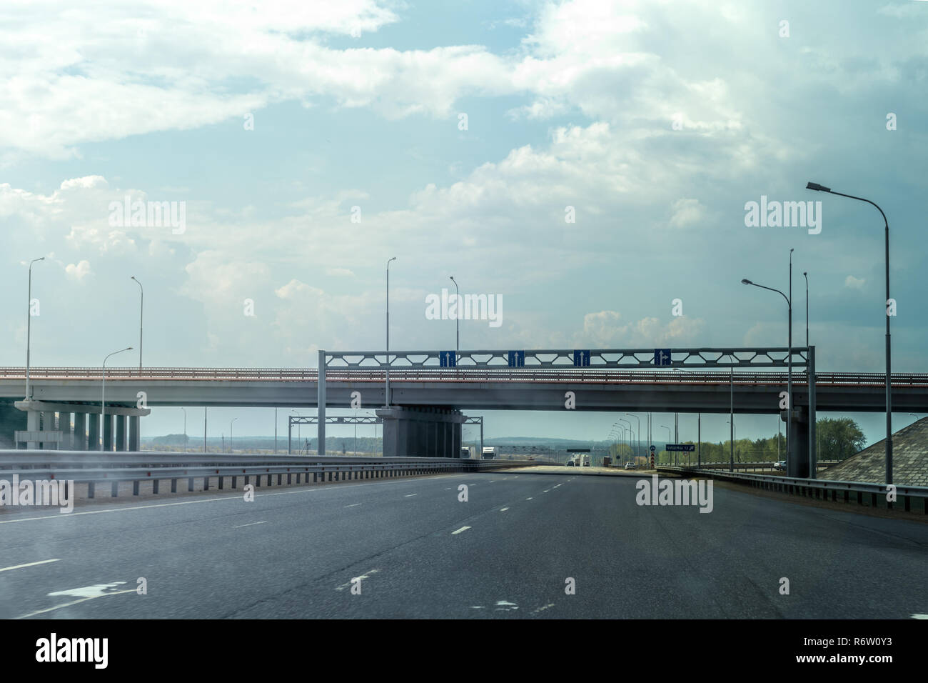 A modern highway, avtstrada with an overpass bridge under the blue sky Stock Photo