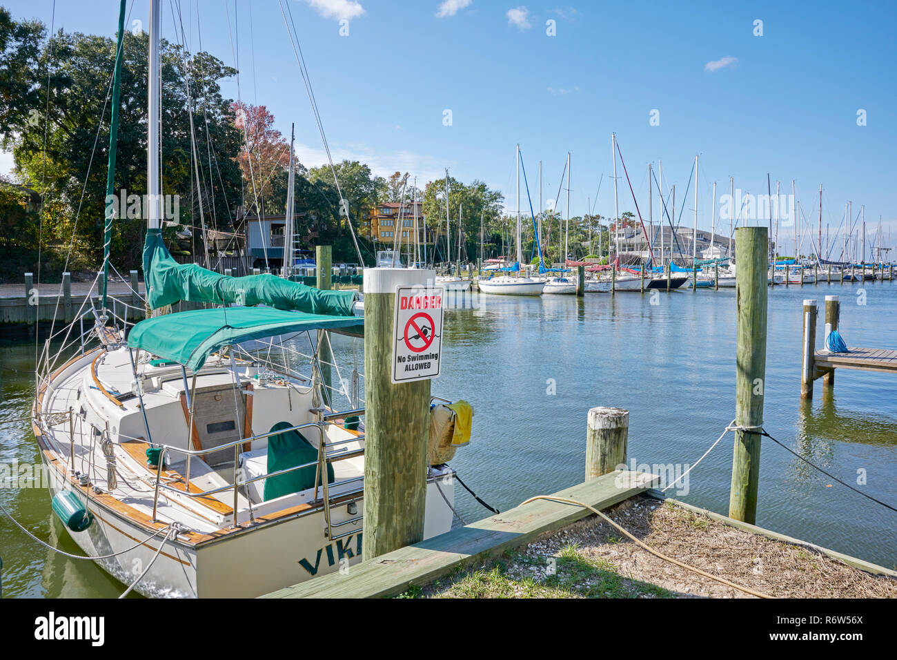 Sailboats tied up and lined up in boat slips at Fly Creek Marina on Mobile Bay, in Fairhope Alabama, USA. Stock Photo