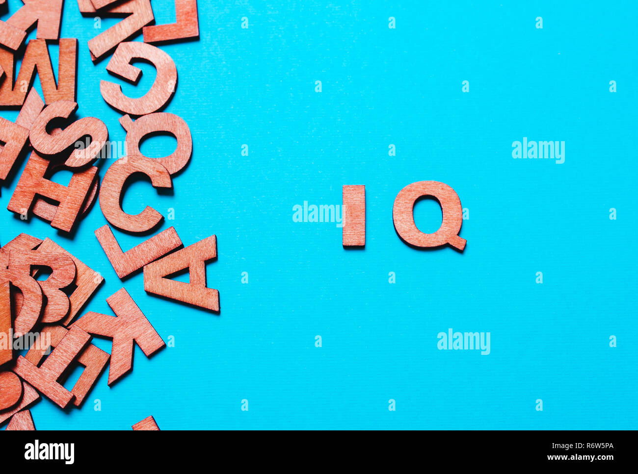 Word ,abbreviation IQ of wooden letters on a blue background Stock