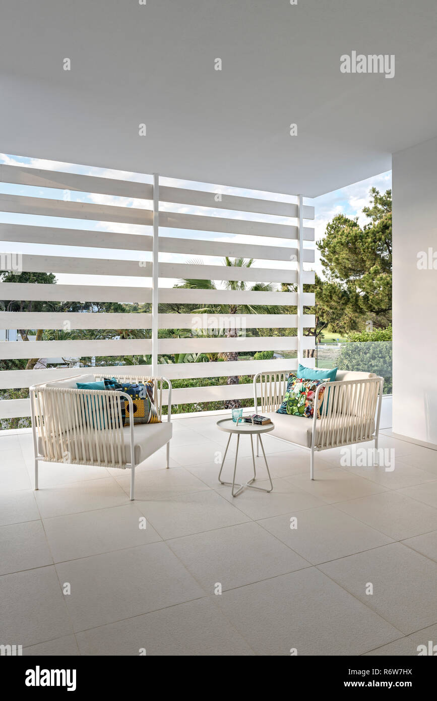 Pair of rope and metal armchairs on screened terrace in new build villa ...