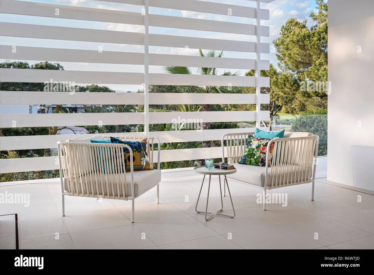 Pair of rope and metal armchairs on screened terrace in new build villa, Quinta do Lago Stock Photo